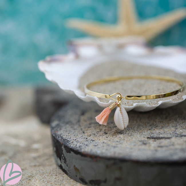Beadle Goudkleurige platte armband met cowrie schelp en peach kwastje