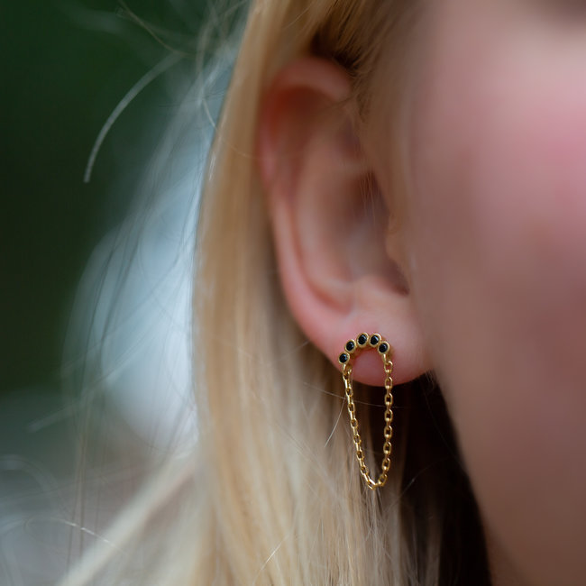 Gouden oorbellen met zwarte steentjes en ketting.