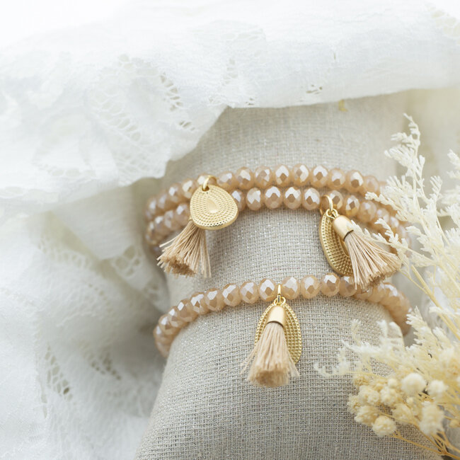 Beige stylish armband met munt en kwast voor tijdloze outfit