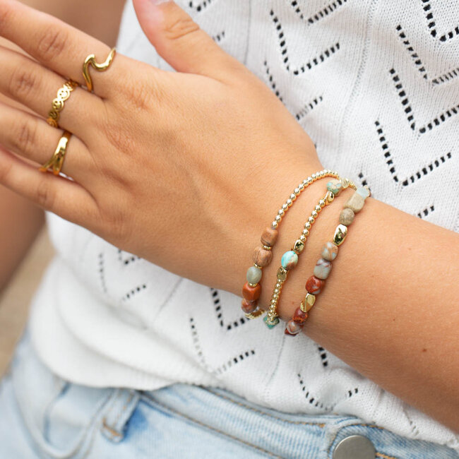 Armbanden in goud met turquoise en bruine kralen