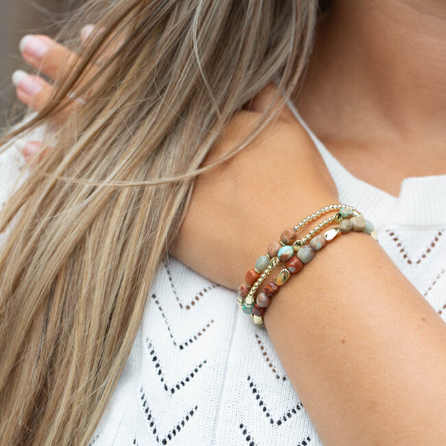 Armbanden in goud met turquoise en bruine kralen