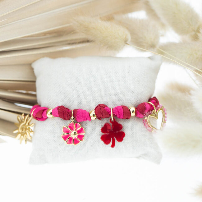 Rood roze geknoopte armband met bloem en klaver bedels
