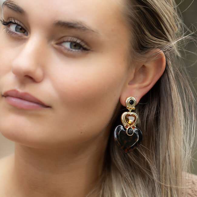 Grote oorbellen met hartvorm, gouden details en warme bruintinten.