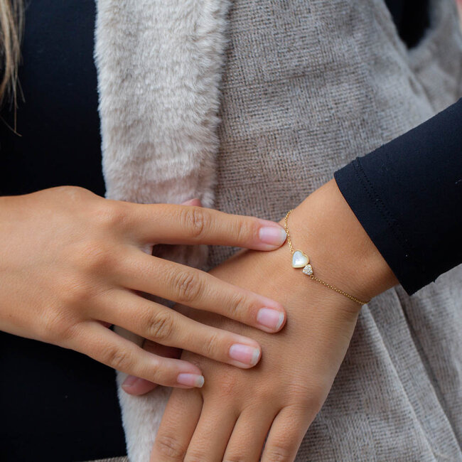 Gouden armband met dubbel hart parelmoer en glitter