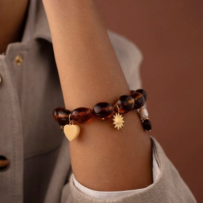 Warme bruine armband met grote kralen en vrolijke bedels