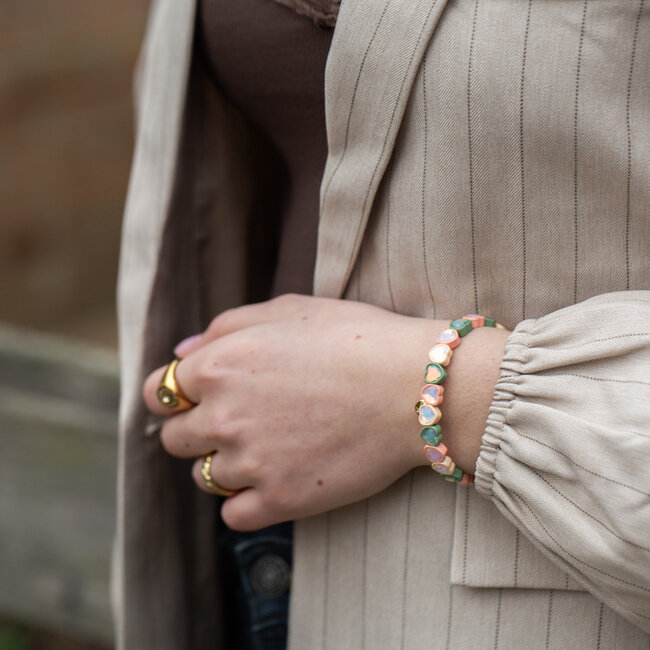 Elastische armband met crystal hartjes in groen en roze
