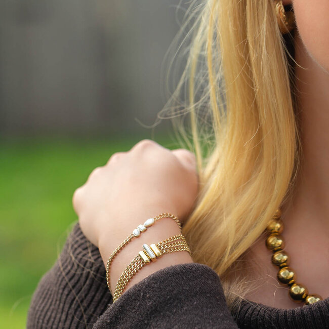Goudkleurige armbanden met witte stenen