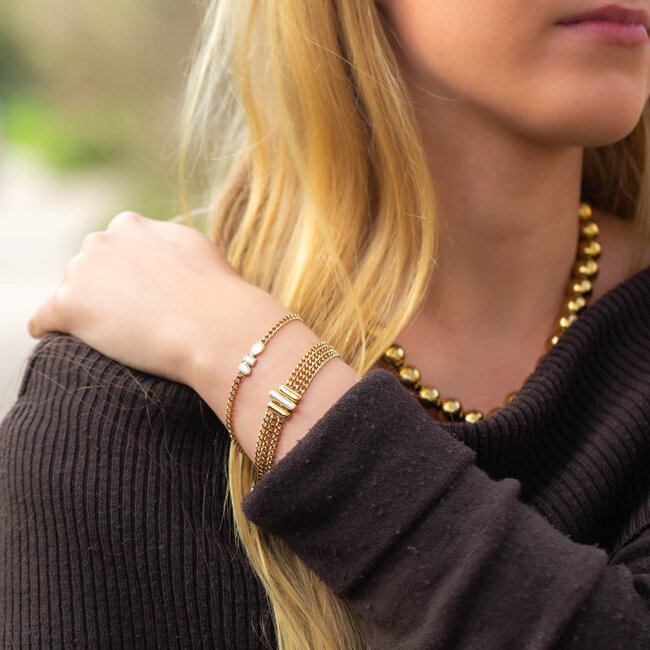 Goudkleurige armbanden met witte stenen
