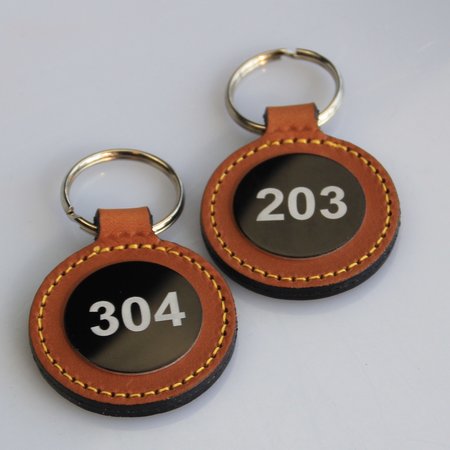 Leren of Kunstleren sleutelhangers Ø45x75mm met jouw nummering en eventueel met een logo op de voorkant of de achterkant.