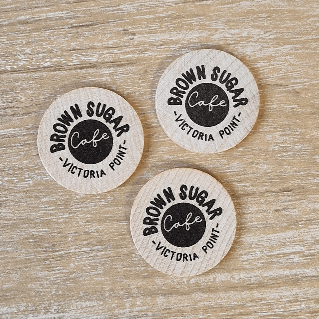 Overview van drie houten consumptiemunten zwart bedrukt