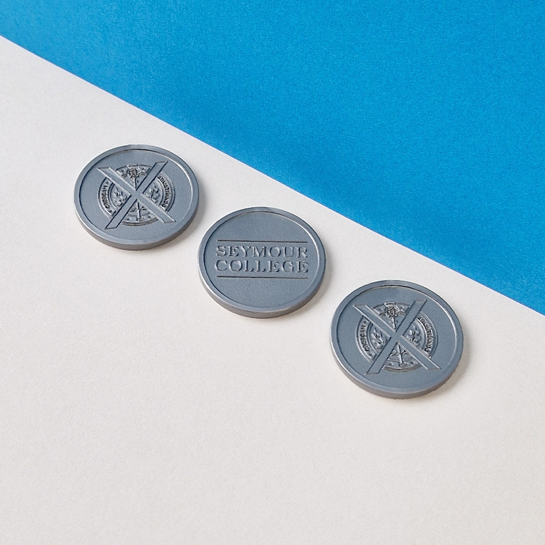 Overview van drie plastic reliëf munten naast elkaar