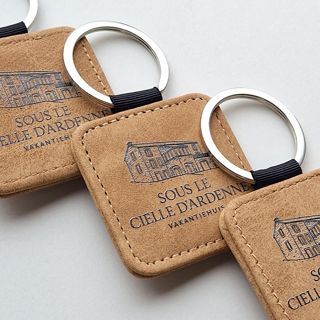 Detail van overzicht drie bruine leren sleutehangers liggend op elkaar