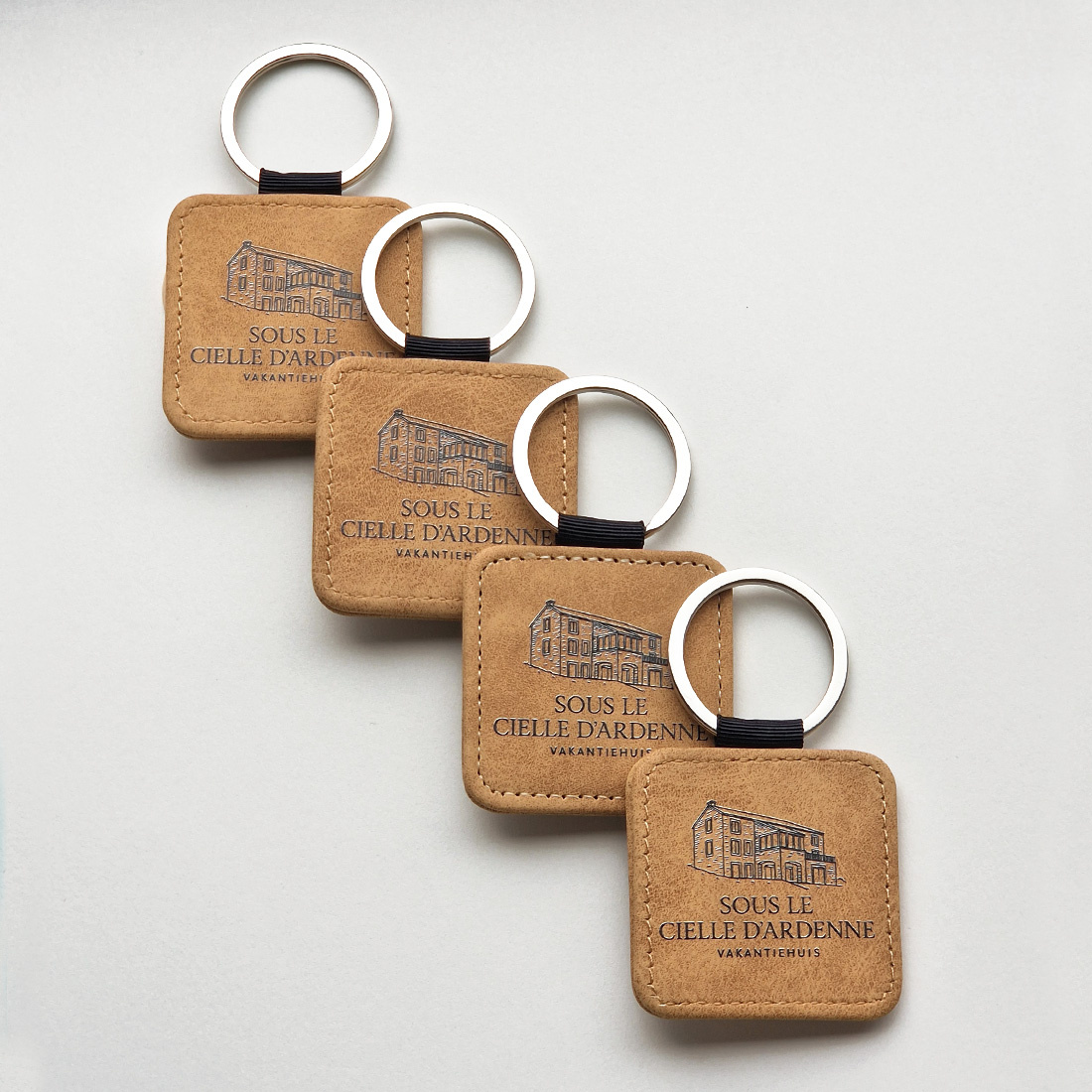 Overview van drie bruine sleutelhanger met bedrukking op elkaar