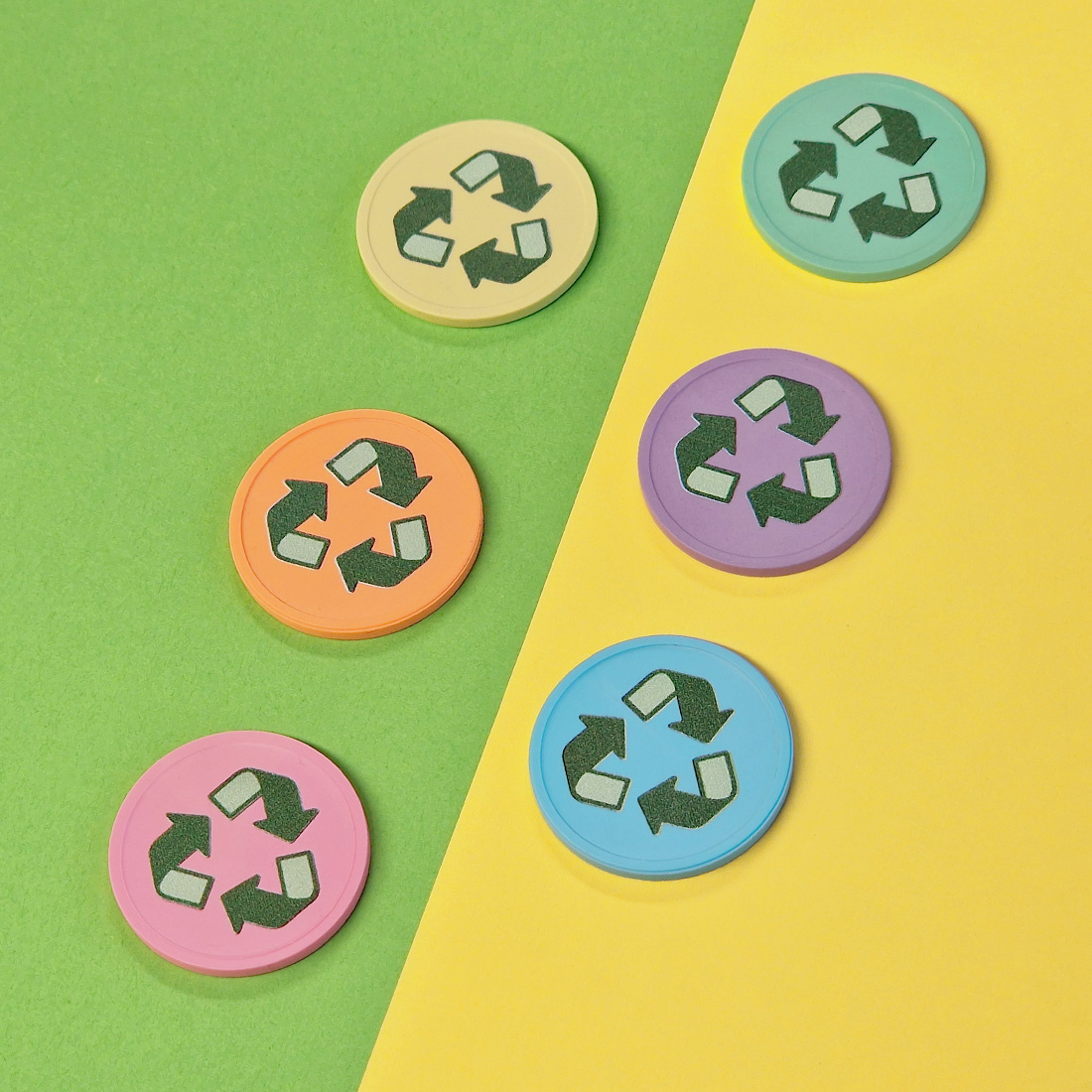 Overview van zes plastic gerecyclede munten naast elkaar met recycle icoon