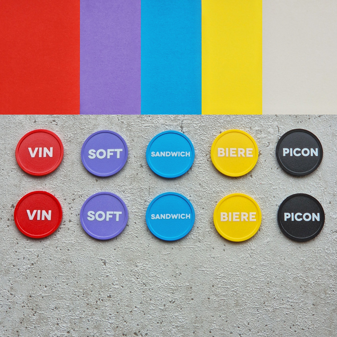 Overview van gekleurde plastic munten bedrukt met franse tekst naast elkaar
