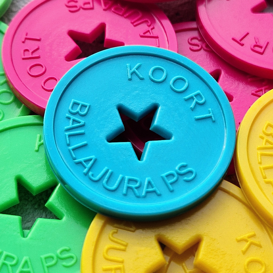 Detail close up gekleurde plastic ronde reliëfmunten met gat in stervorm