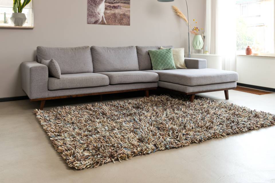 Moet een vloerkleed onder of voor de bank?