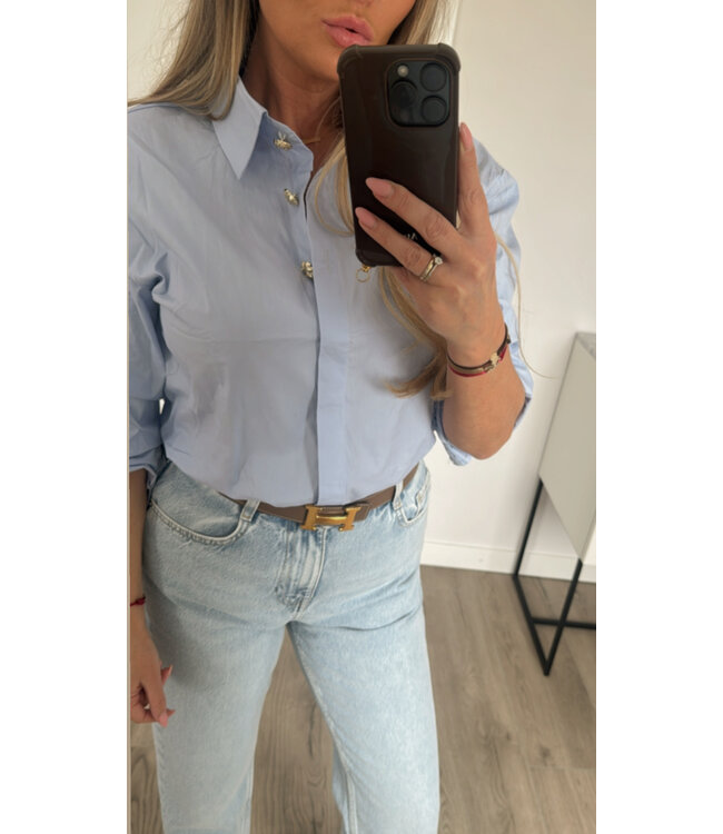 Blauwe blouse gouden knopen