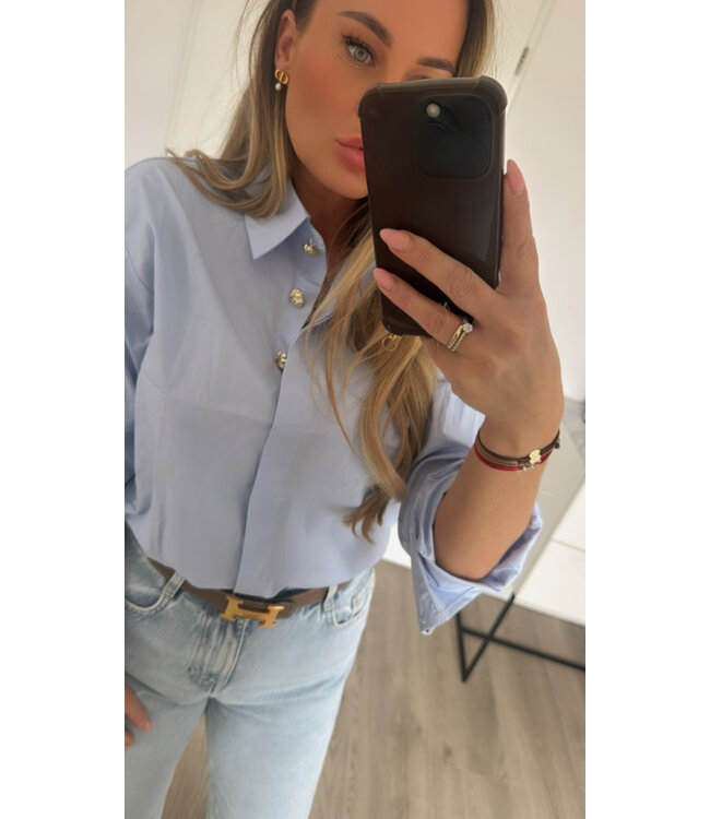 Blauwe blouse gouden knopen