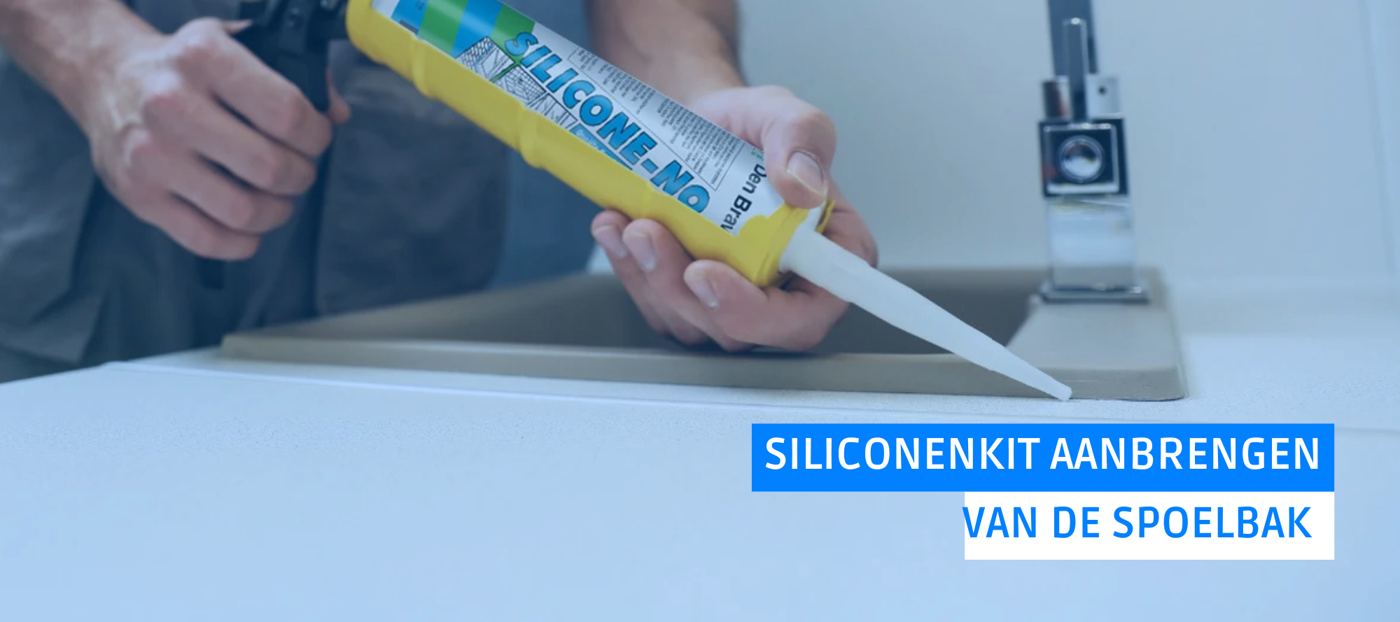 Het aanbrengen van de kit met een kitpistool en afplaktape langs de rand van een spoelbak.