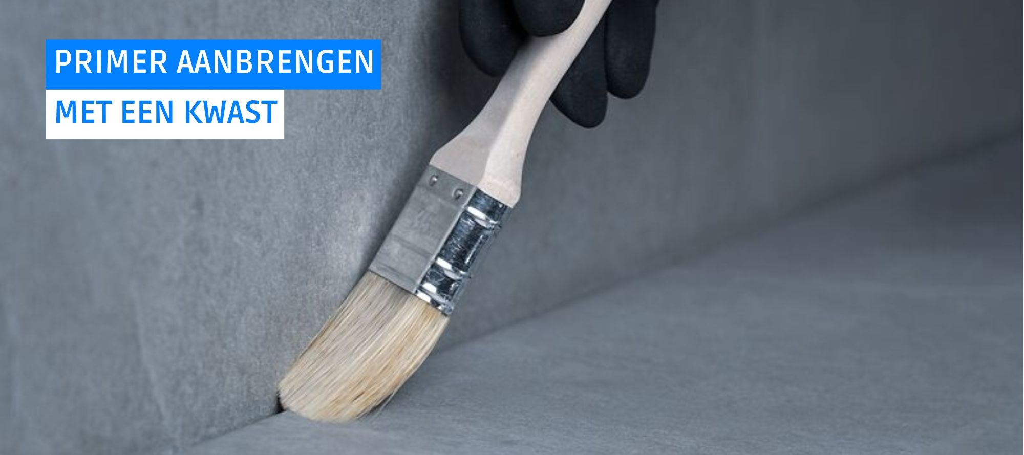 Een close-up van een kwast die een hechtprimer aanbrengt.