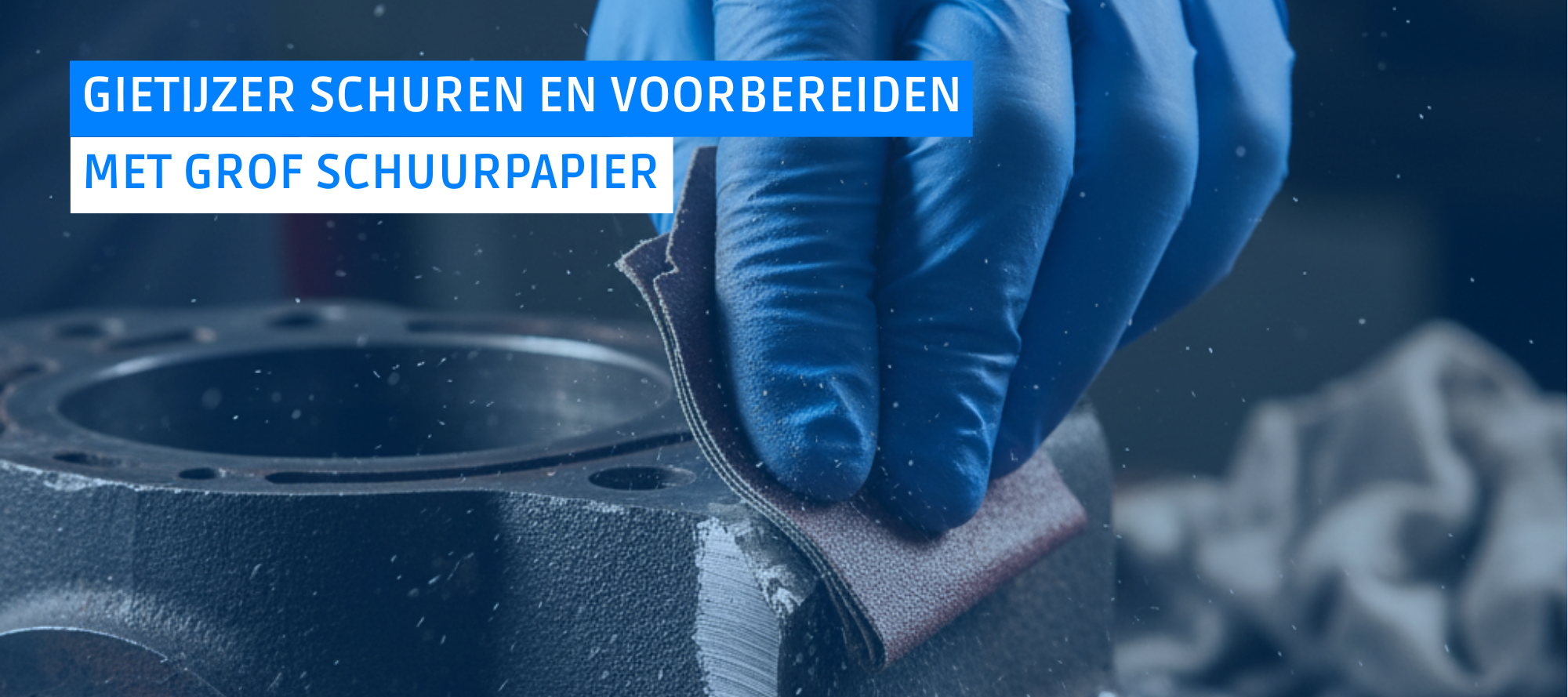 Een persoon die een gietijzeren breukvlak schuurt met grof schuurpapier om het oppervlak op te ruwen en voor te bereiden op lijmen.