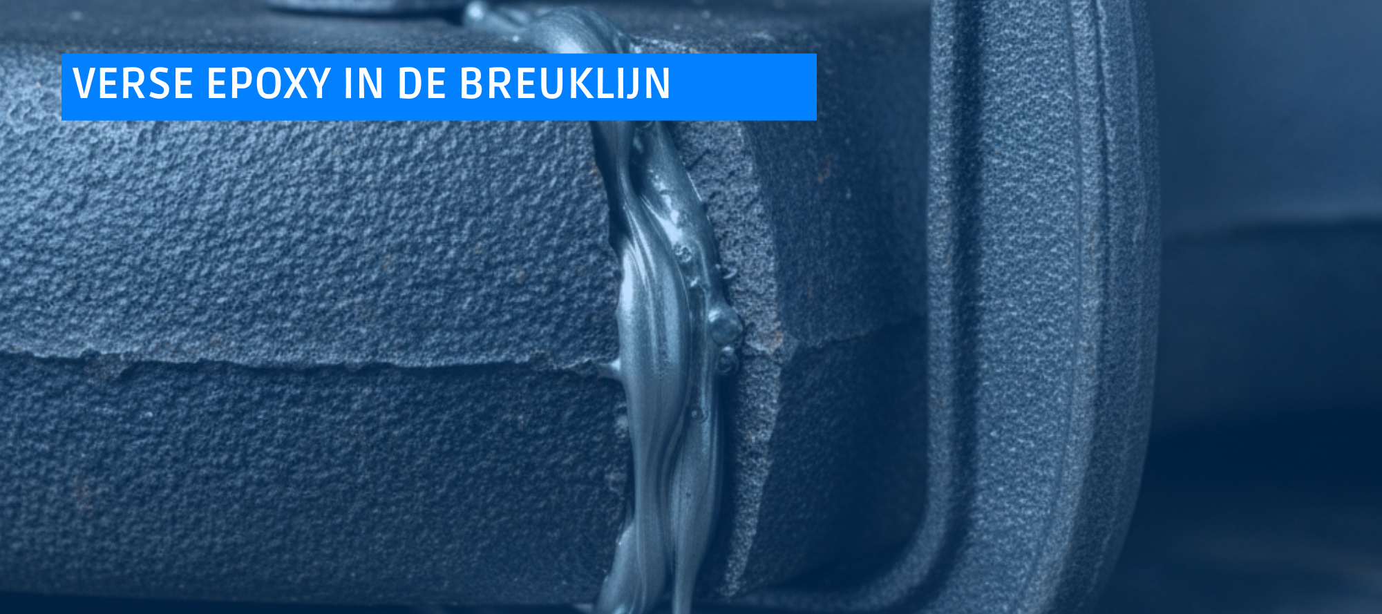 Een detailfoto van twee geklemde stukken gietijzer met verse epoxy in de breuklijn, wat het belang van klemmen bij gietijzer lijmen illustreert.