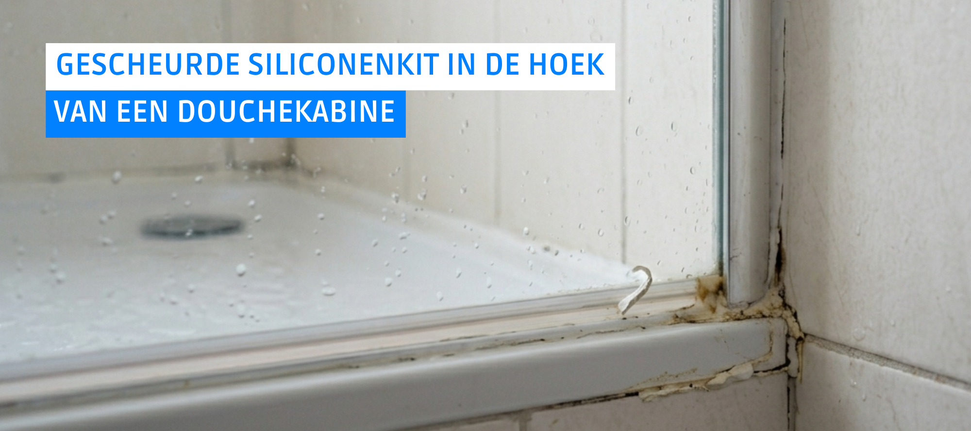 Gescheurde siliconenkit in de hoek van een badkamer door materiaalwerking en een te smalle voeg