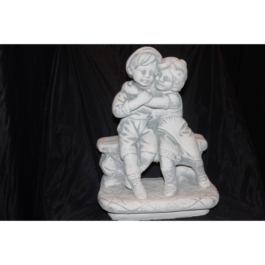 Knuffelend jongetje en meisje op bankje als betonnen tuinbeeld-1