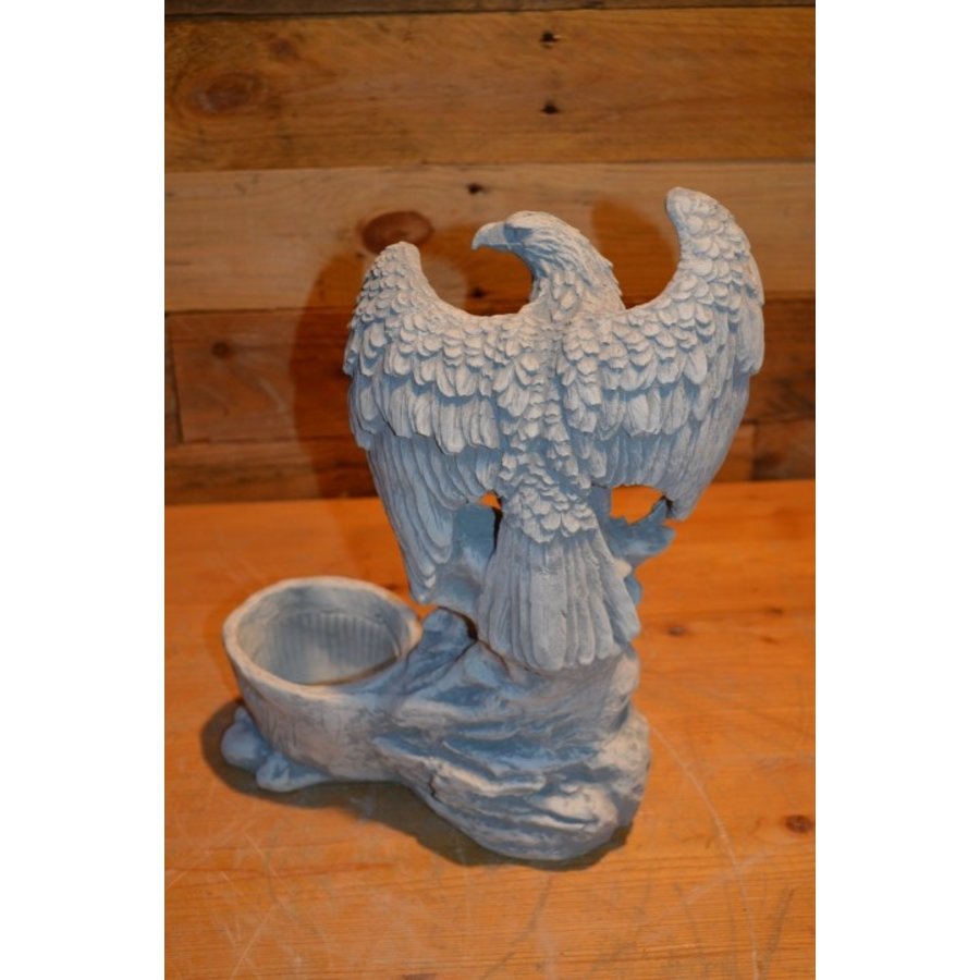 Adelaar met gespreide vleugels op rots naast betonnen bloempotje-3