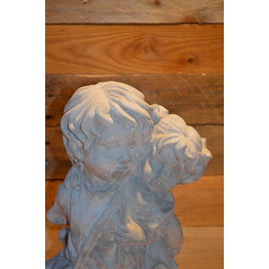 Betonnen kinderbeeld – broertje draagt zijn zusje op de rug-2