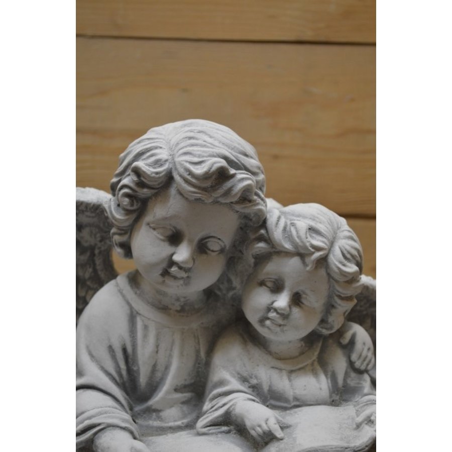 Betonnen beeld van twee engelen die samen een boek lezen-5