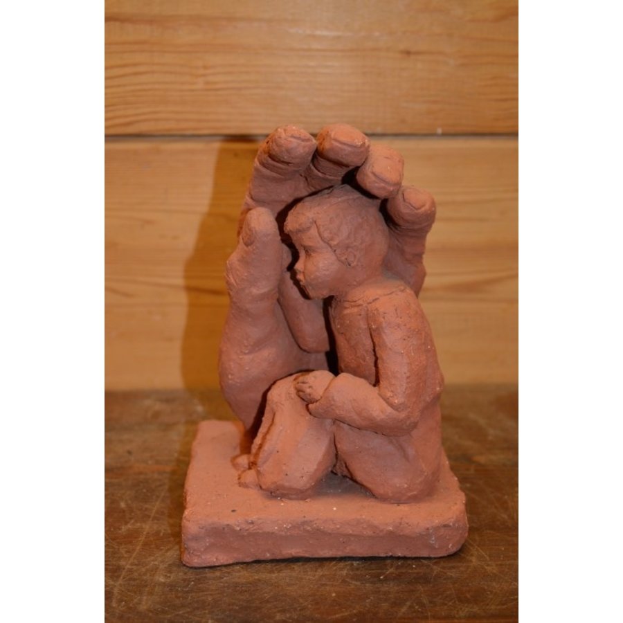 Gipsen beeldje van kindje onder of achter beschermende hand-2