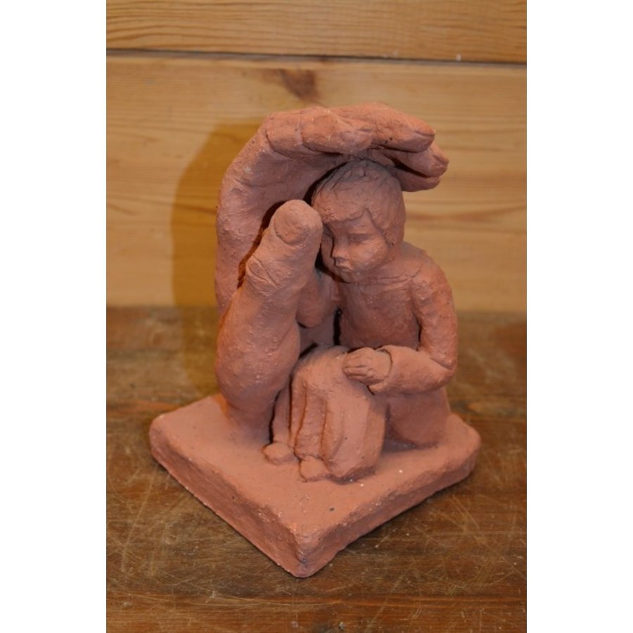 Gipsen beeldje van kindje onder of achter beschermende hand-1