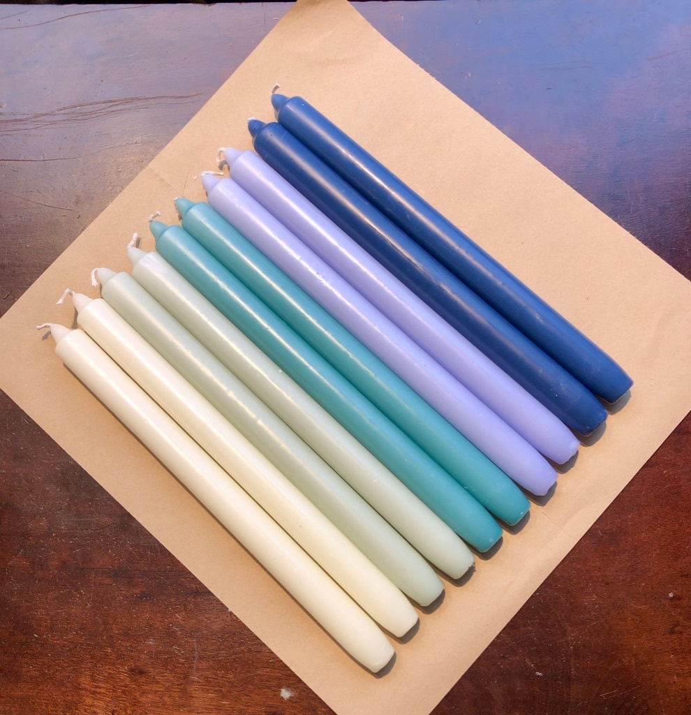 A package with 10 candles in colours that makes you think of the sea
