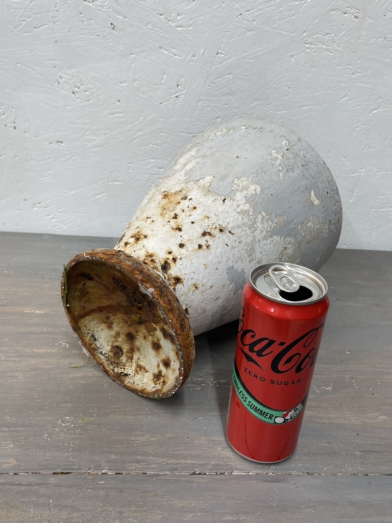 Antique cast iron vase, leaning a bit