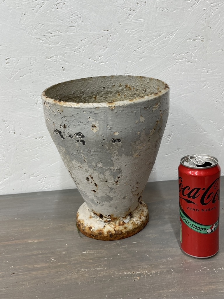 Antique cast iron vase, leaning a bit