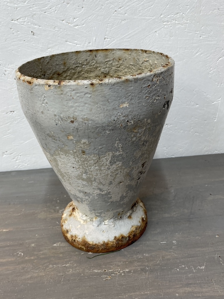Antique cast iron vase, leaning a bit