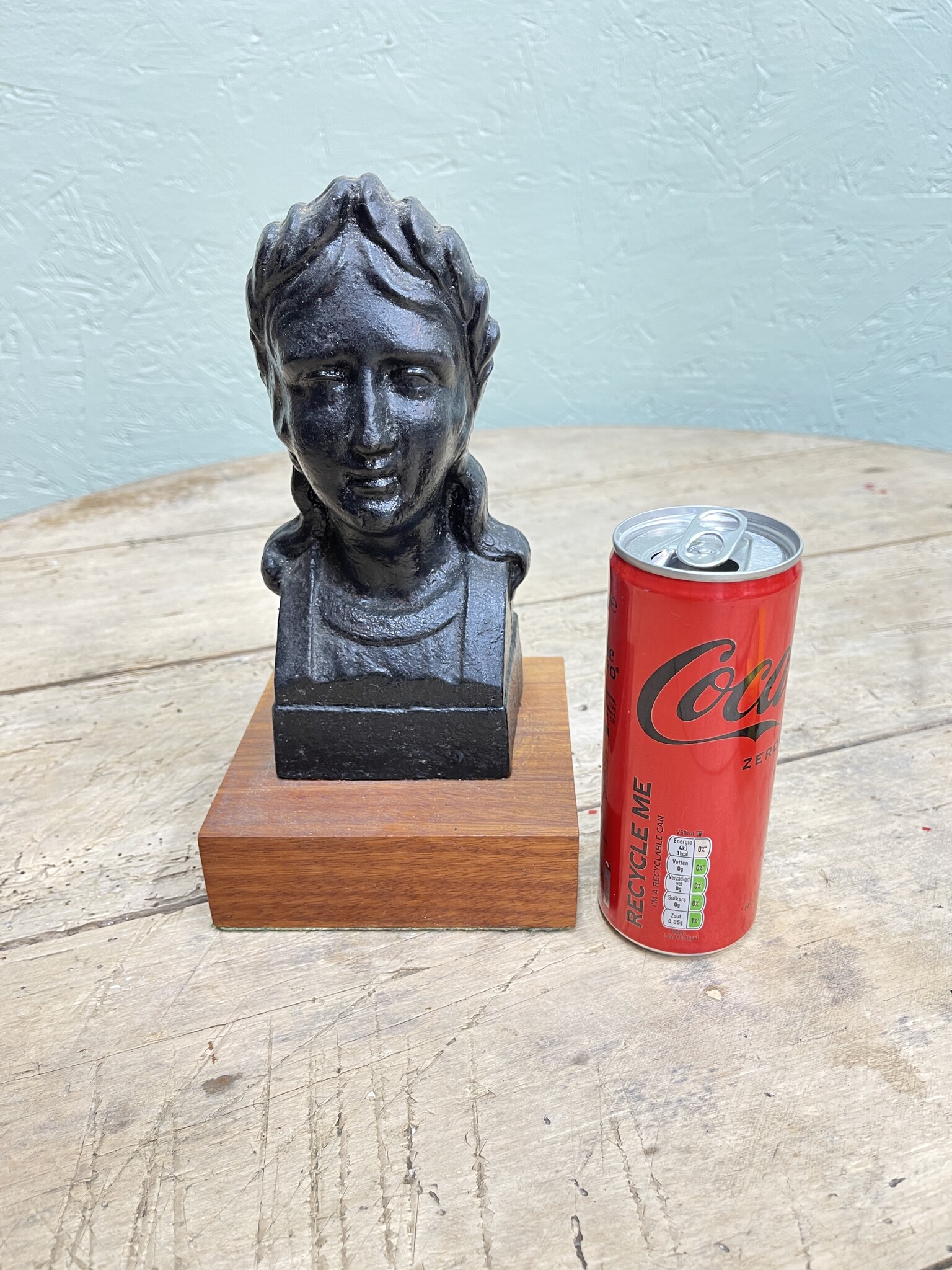 Old statue of a dame mounted on a wooden console