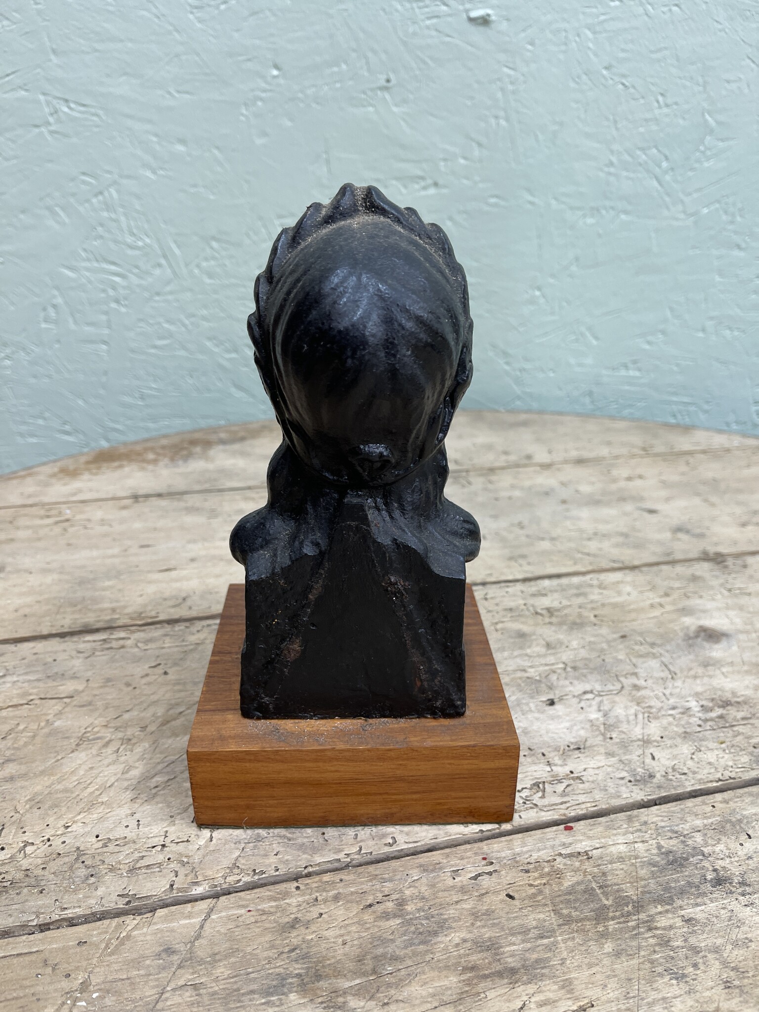 Old statue of a dame mounted on a wooden console