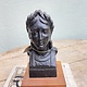 Old statue of a dame mounted on a wooden console