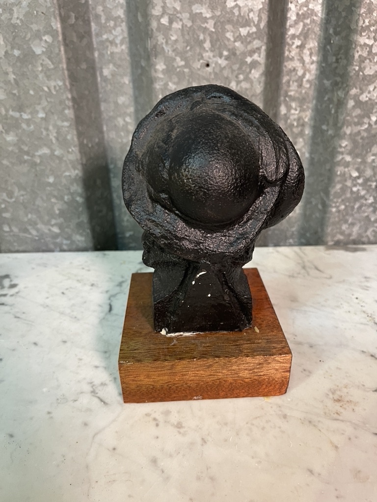 Old statue of a distinguished gentleman on a wooden console