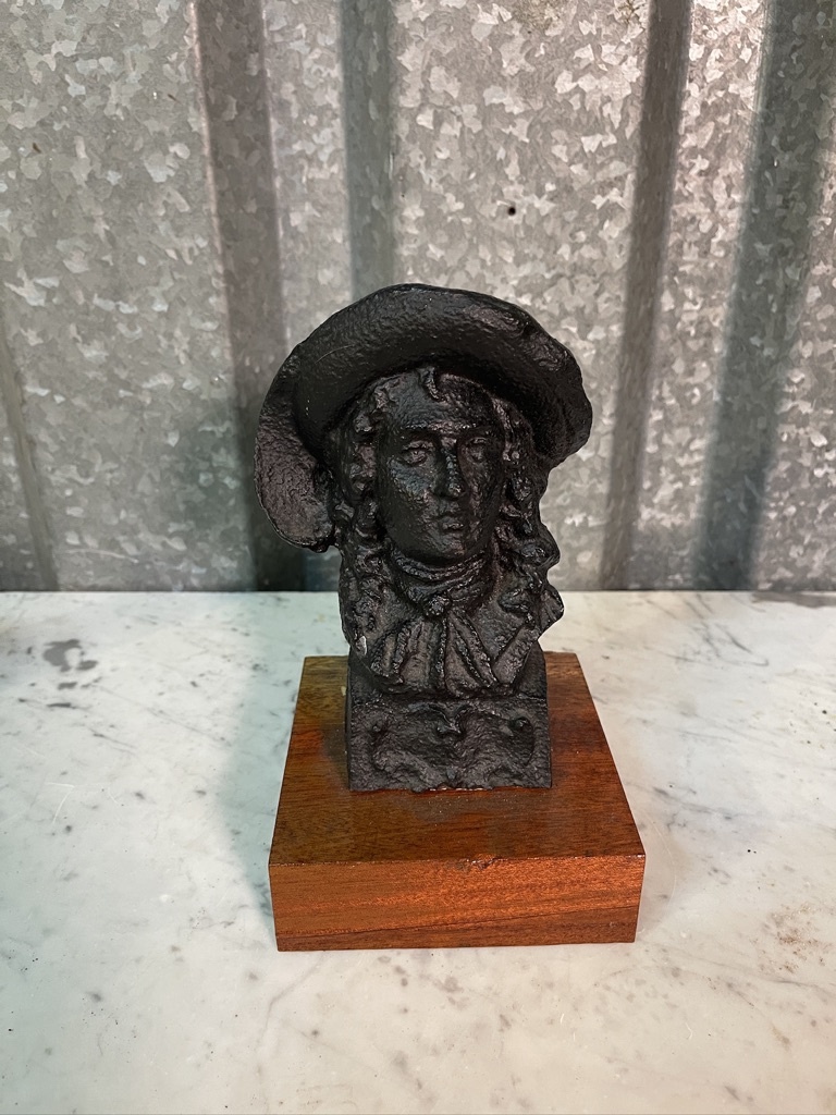 Old statue of a distinguished gentleman on a wooden console