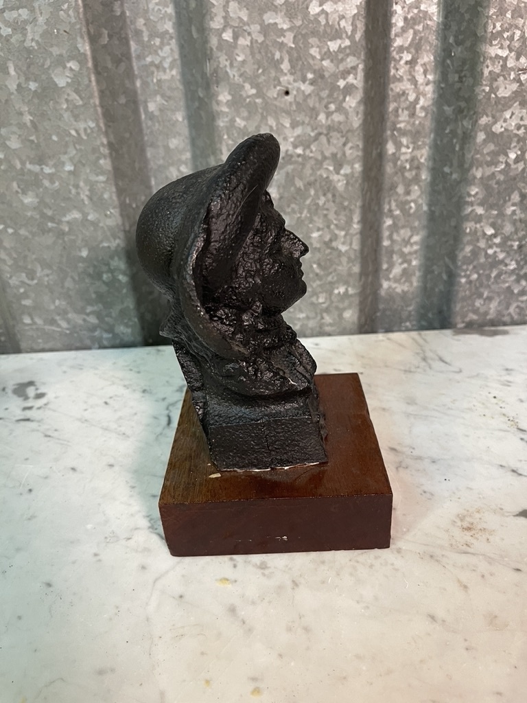 Old statue of a distinguished gentleman on a wooden console