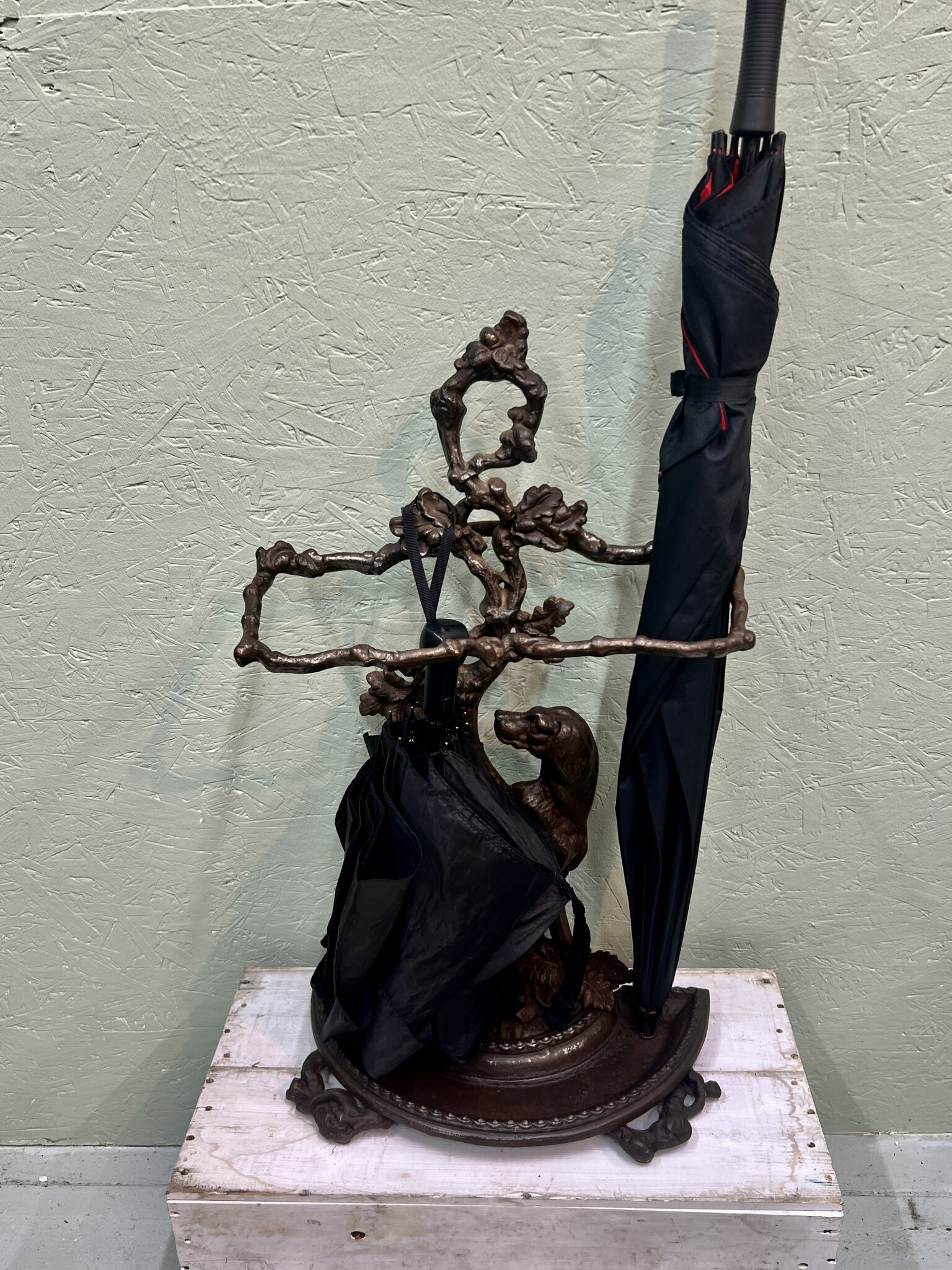 Oude gietijzeren paraplustandaard met lieve hond