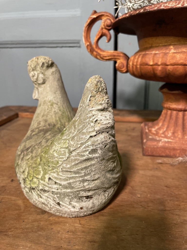 Old statue of a chicken with wear