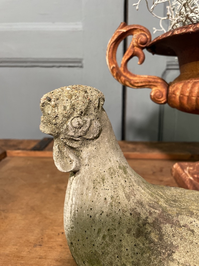 Old statue of a chicken with wear