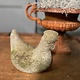 Old statue of a chicken with wear