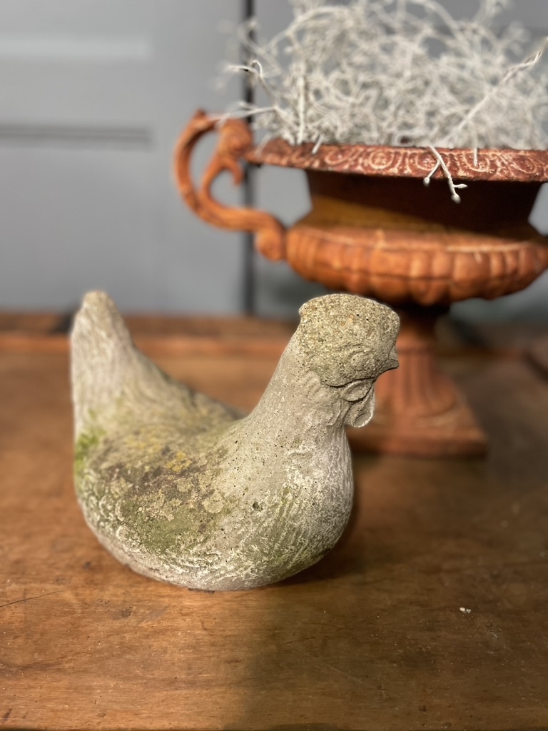 Old statue of a chicken with wear