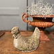 Old statue of a chicken with wear